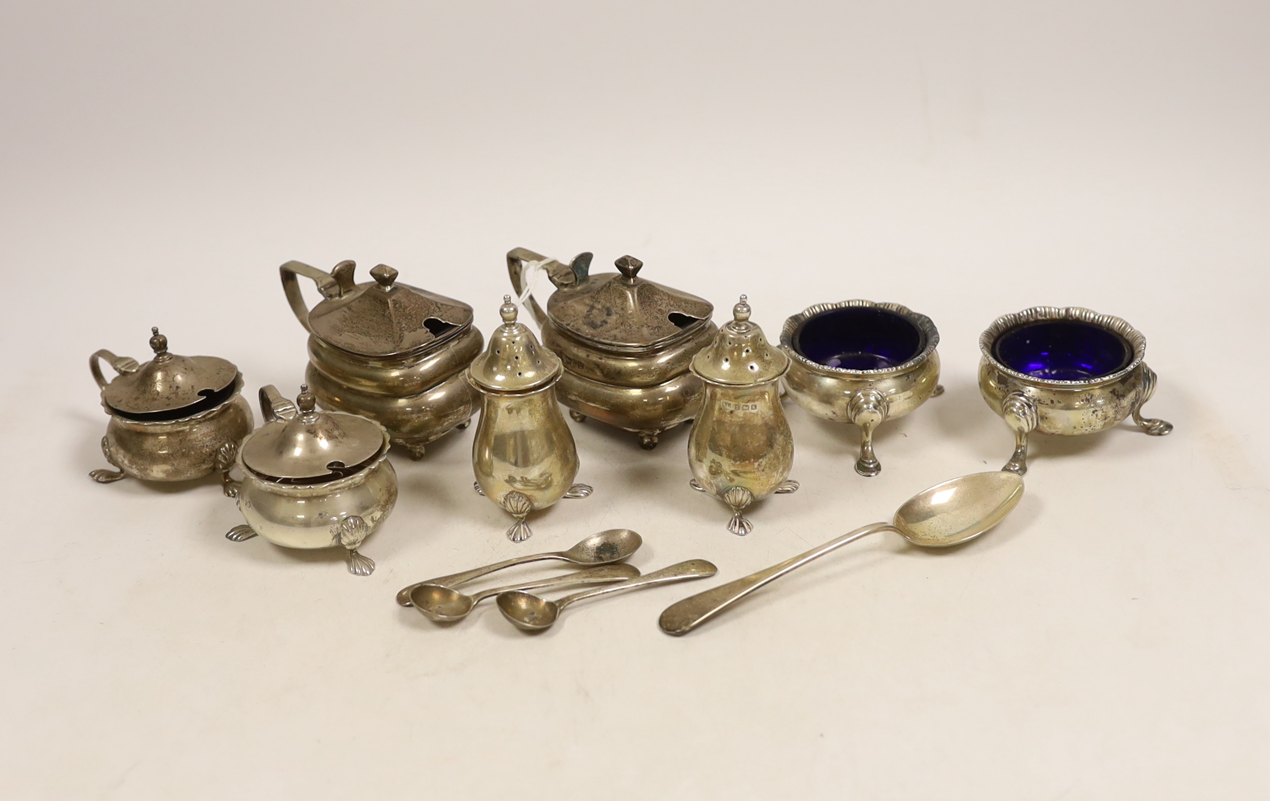 A pair of George V oblong silver lidded mustards with blue glass liners, two other mustards, a pair of peppers, a pair of 'cauldron' salts, three condiment spoons and a teaspoon.